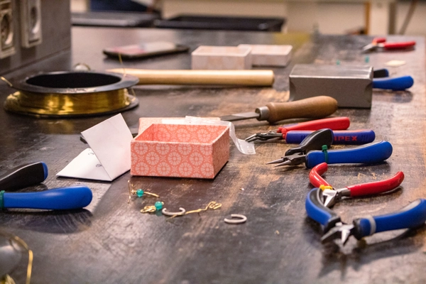 Billede af en arbejdsplads, tænger, smykker og materiale